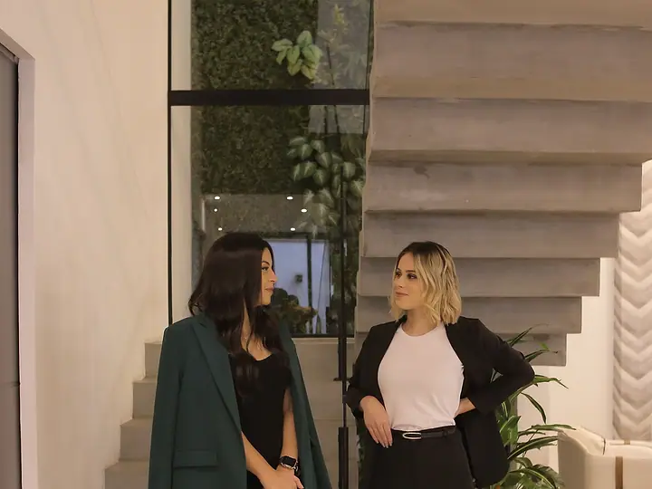 As advogadas Akemy Rande de Sousa e Letícia Moreira Amora em pé, junto a uma escada de concreto